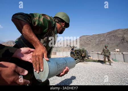 02 août 2009 - FOB Kala Gush, Nangahar, Afghanistan - un soldat de l'Armée nationale afghane court pour apporter des munitions pour un canon d'artillerie russe D30 de 120 mm tirant sur des positions taliban depuis la base opérationnelle avancée de Kala Gush dans les montagnes de l'Hindu Kush près de la frontière pakistanaise (crédit image : Simon Klingert/ZUMAPRESS.com) Banque D'Images