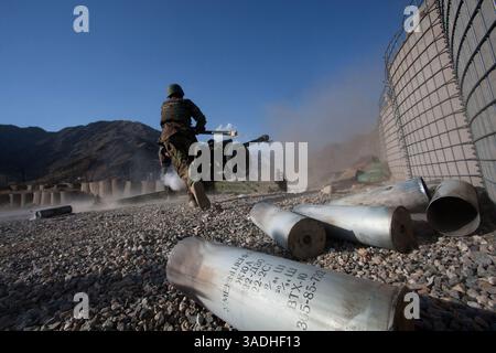 02 août 2009 - FOB Kala Gush, Nangahar, Afghanistan - un soldat de l'Armée nationale afghane jette des munitions usagées pour un canon d'artillerie D30 de 120 mm de fabrication russe tirant sur des positions taliban à partir de la base opérationnelle avancée de Kala Gush dans les montagnes Hindu Kush près de la frontière pakistanaise (crédit image : Simon Klingert/ZUMAPRESS.com) Banque D'Images