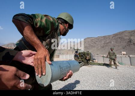 02 août 2009 - FOB Kala Gush, Nangahar, Afghanistan - un soldat de l'Armée nationale afghane court pour amener la charge explosive qui propulse l'obus d'un canon d'artillerie russe D30 de 120 mm lors d'une mission de tir à la base opérationnelle avancée de Kala Gush dans la province du Nouristan (crédit image : Simon Klingert/ZUMAPRESS.com) Banque D'Images