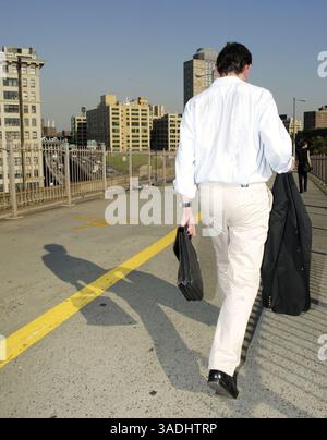 14 août 2003 ; Brooklyn, NY, États-Unis ; le réseau électrique de l'Ohio tombe en panne dans les principales villes de la côte est des États-Unis et du Canada, notamment New York, Hartford, Cleveland, Detroit, Toronto et Ottawa. Les New-Yorkais descendent dans les rues, les métros s'arrêtent dans une chaleur record et quatre centrales nucléaires sont fermées dans l'Ohio et l'État de New York. La sécurité intérieure et le maire de New York, Michael Bloomberg, ont déclaré qu'il n'y avait aucune preuve de terrorisme comme cause. Sur la photo : avec le métro toujours fermé après le plus grand black-out de l'histoire des États-Unis, les New Yorkers se déplacent à pied sur le pont de Brooklyn pour se rendre à Brooklyn. Banque D'Images