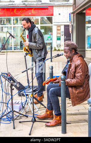 Michel Aubenas à la guitare accompagné d'un sax dans la performance de rue Rock and Blues - Chatellerault, Vienne (86), France. Banque D'Images