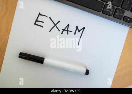 examen word écrit avec un stylo noir sur papier - un rappel du collage scolaire ou de l'évaluation du travail Banque D'Images