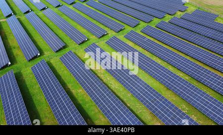 Une grande ferme de centrales solaires avec plusieurs rangées de panneaux photovoltaïques générant de l’énergie renouvelable. Centrale solaire, électricité écologique. Banque D'Images