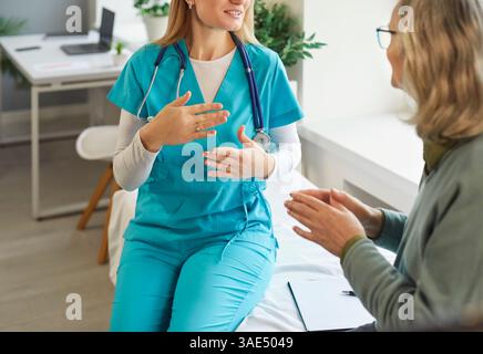 Médecin féminin assis sur le canapé, expliquant le diagnostic et discutant du traitement avec le patient senior. Banque D'Images