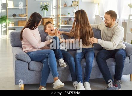 Heureux parents et enfants s'amusant et chatouillant les uns les autres Banque D'Images