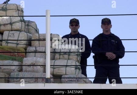 15 mars 2002 ; San Diego, CA, États-Unis ; les gardes-côtes se tiennent à côté de balles de cocaïne, tandis que le vice-amiral Ray Riutta, commandant de la zone Pacifique des gardes-côtes américains rencontre les médias d'information @ 32nd Street Navel Station. La conférence de presse a suivi le retour du Pacifique est de 4 coupeurs de la Garde côtière américaine qui ont participé à l’opération New Frontier, qui a permis de récolter 19,5 tonnes de cocaïne et 5,5 tonnes de marijuana. (Crédit image : Earl S. Cryer/ZUMAPRESS.com) Banque D'Images