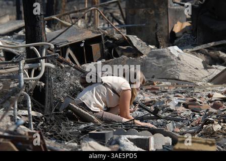 Oct 26, 2007 - San Diego, CA, États-Unis - NEDDY FONSECA fouille les décombres de sa belle-mère brûlée dans le quartier de Rancho Bernardo à San Diego. Les résidents ont entamé le processus de nettoyage et de rétablissement alors que les pompiers combattent encore cinq incendies majeurs dans le nord et l'est du comté (crédit image : Earl S. Cryer/ZUMAPRESS.com) Banque D'Images