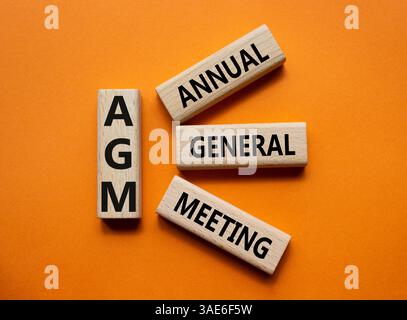 AGA - symbole de l'Assemblée générale annuelle. Mot concept AGM sur cubes en bois. Beau fond orange. Business et AGM concept. Copier l'espace. Banque D'Images