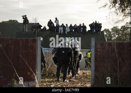20 octobre 2011 - Londres, Royaume-Uni - les manifestants et les médias regardent depuis le toit d'une maison le 2e jour à Dale Farm près de Basildon, à l'est de Londres, le 20 octobre 2011. La police anti-émeute a pris le contrôle du plus grand site de voyageurs illégaux de Grande-Bretagne après avoir rencontré une résistance violente et un barrage de missiles en entrant dans le camp. Des militants chevronnés, qui ont rejoint les résidents, ont lancé des briques sur les officiers, leur ont balancé des pique et ont incendié une caravane mercredi au c (crédit image : © Ki Price/ZUMAPRESS.com) Banque D'Images