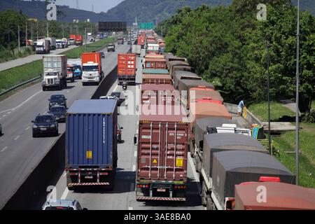 Santos, SP, Brésil - 28 mars 2014 : les camions porte-conteneurs et les voitures sont dans une longue file d'attente dans un embouteillage sur l'autoroute Anchieta, près du port de Santos. Banque D'Images