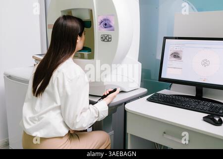 Test oculaire périmétrique pour le signe précoce du glaucome chez une patiente de clinique ophtalmologique. Test de champ visuel périmétrique pour mesurer toutes les zones de la vue Banque D'Images