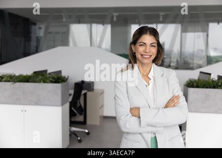 Heureux confiant belle femme d'affaires hispanique posant dans un bureau élégant Banque D'Images