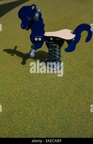 Un cavalier à ressort en forme de mouton (rocker à ressort) dans une aire de jeux publique, jeux d'enfance, symbolique Banque D'Images