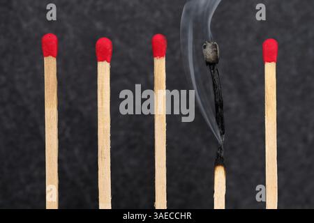 match unique fraîchement brûlé avec une fumée croissante entre les nouveaux matchs inutilisés, concept de syndrome d'épuisement professionnel, stress, épuisement et équilibre travail-vie privée Banque D'Images