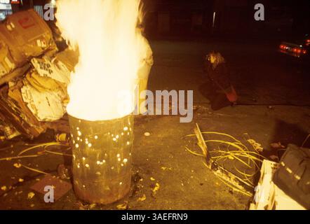 10 juillet 2000 ; New York, NY, États-Unis ; un sans-abri se réchauffe près du feu lors d'une nuit d'hiver très froide dans le quartier du "marché de la viande" de Manhattan. (Crédit image : Rob Schoenbaum/ZUMAPRESS.com) Banque D'Images