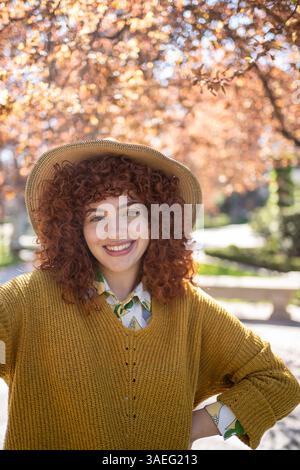 Une femme joyeuse souriante dans une tenue d'automne à la mode, incarnant la chaleur et le style Banque D'Images