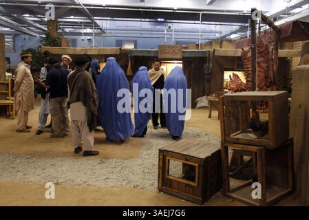 20 octobre 2011 - Camp Lejeune, NC, États-Unis - les joueurs de rôle errent dans une maquette d'un marché rural afghan alors que les Marines de la compagnie Bravo, 2e peloton, 1er bataillon 8e Marines, 2e division des Marines se préparent à démarrer une simulation dans le nouvel entraîneur d'immersion d'infanterie MCBCL au Camp Lejeune, Caroline du Nord, le 20 octobre 2011. L'entrepôt converti de 32 000 pieds carrés soutient la formation de petites unités dans la maquette d'un village rural afghan. (Crédit image : © Chuck Liddy/Raleigh News & observer/MCT/ZUMAPRESS.com) Banque D'Images