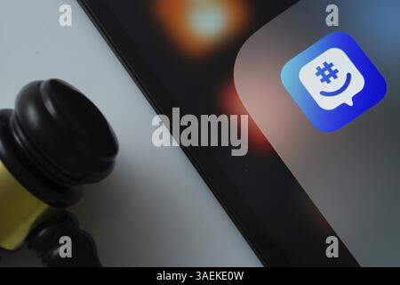 Gros plan d'un écran iPad affichant l'application GroupMe à côté d'un marteau de juge Banque D'Images