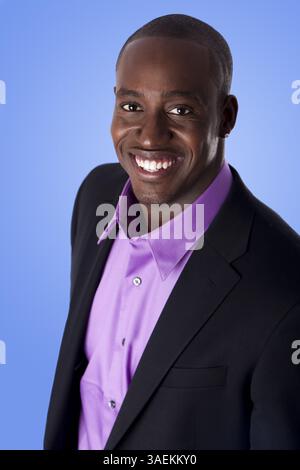 Beau homme d'affaires afro-américain heureux souriant, portant un costume noir avec chemise violette, isolé, New York, États-Unis, Amérique du Nord Banque D'Images