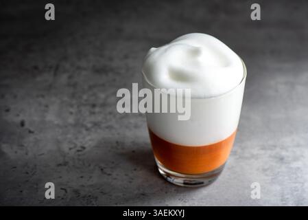 Latte de thé thaïlandais chaud avec mousse de lait dans le verre. Banque D'Images