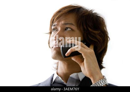 Jeune homme d'affaires asiatique avec appel de téléphone mobile, isolé, New York, Etats-Unis, Amérique du Nord Banque D'Images