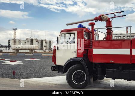 Un camion d'incendie avec un pistolet à mousse spécial sur la cabine est en service dans une raffinerie de pétrole Banque D'Images