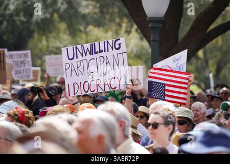 Un manifestant tient une pancarte indiquant « non volontaire participant d'une idiocratie » lors d'une manifestation anti-Trump au capitole de l'État du Texas le 8 mars 2025 à Austin, Texas, États-Unis. (Photo de Julia Beverly/Alamy Live News) Banque D'Images