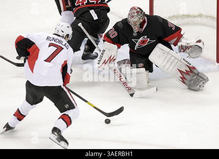 25 octobre 2011 - Raleigh, NC, États-Unis - le Cam Ward des Hurricanes de Caroline (30) défend contre David Rundblad des sénateurs d'Ottawa (7) lors de la deuxième période d'un match de la LNH au Centre RBC à Raleigh en Caroline du Nord, le mardi 25 octobre 2011. (Crédit image : © Chris Seward/Raleigh News & observer/MCT/ZUMAPRESS.com) Banque D'Images