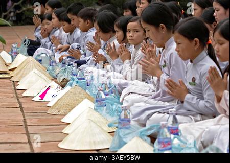 27 février 2005 ; Hue, Vietnam ; les jeunes dévots prient avant de manger à la pagode Thien Mu. Banque D'Images