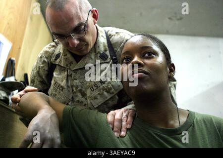 30 mars 2005 ; Camp Blue Diamond, Irak ; HN DAVID J. FLECK examine l'épaule d'un patient, mars 30, au poste de secours du bataillon du quartier général. Fleck est un corpsman de 35 ans originaire de Norfolk, en Virginie, déployé dans le bureau du chirurgien de la 2e Division des Marines. Banque D'Images