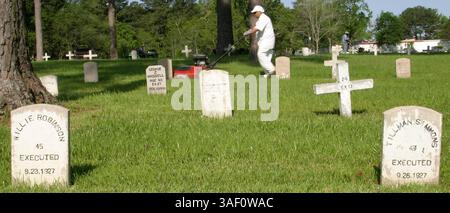 13 avril 2005 ; Huntsville, TX, États-Unis ; un prisonnier tond le cimetière des geôliers de Huntsville. L'unité d'exécution basée au Texas à Huntsville, également connue sous le nom de « The Walls Unit », en raison des murs de briques qui entourent la prison, abrite le couloir de la mort, où les condamnés sont détenus dans de petites cages de verre et d'acier pendant 23 heures toutes les 24 heures. Au moins 341 prisonniers ont été exécutés au Texas depuis 1982. Crédit obligatoire : photo de Nadav Neuhaus/ZUMA Press. (©) Copyright 2005 par Nadav Neuhaus Banque D'Images