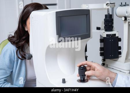 Femme brune soumise à un examen oculaire en clinique ophtalmologique Banque D'Images