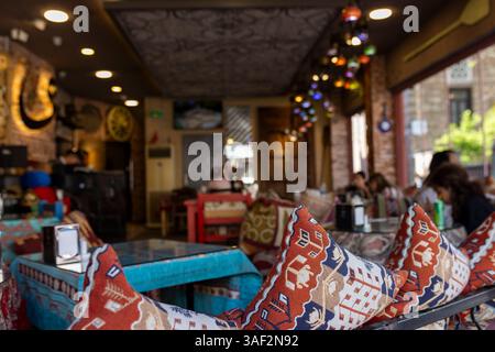 Istanbul, Turquie, 2 mai 2024, intérieur d'un restaurant Capadocia , décoré avec des lampes ornées de style moyen-oriental ou turc, coussins à motifs, Banque D'Images