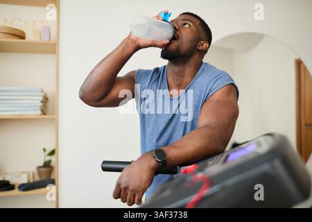 Exercice homme buvant de l'eau pendant l'entraînement Banque D'Images