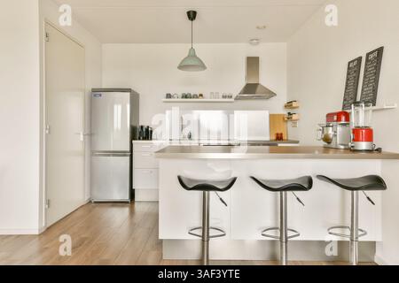 Cette cuisine élégante présente un mobilier moderne, des appareils élégants et une palette de couleurs neutres qui rehausse son attrait minimaliste. Banque D'Images