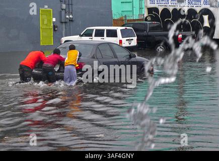 28 février 2015 - Miami, FL, États-Unis - les habitants aident un automobiliste en poussant sa voiture dans une rue inondée alors que plusieurs centimètres de pluie tombent dans le sud de la Floride, provoquant des inondations généralisées dans les rues de Little Haiti à Miami, près du complexe culturel Little Haiti, le samedi 28 février 2015. (Crédit image : © Carl juste/TNS/ZUMA Wire) Banque D'Images
