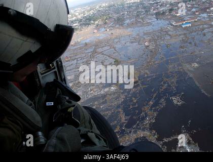 Jan 01, 2005 ; Banda Aceh, Indonésie ; Aviation anti-sous-marine Warfare Operator 2nd Class Timothy Sullivan observe la dévastation sur Banda Aceh, d'un SH-60F Seahawk de la marine américaine affecté à l'escadron anti-sous-marin d'hélicoptère deux (HS-2) ÒGolden Falcons. ó le HS-2 embarqué à bord de l'USS Abraham Lincoln (CVN 72) transporte des fournitures, amène des équipes de secours en cas de catastrophe et soutient les ponts aériens humanitaires vers les régions côtières frappées par le tsunami. Le Abraham Lincoln Carrier Strike Group opère actuellement dans l'océan Indien au large des eaux indonésiennes et thaïlandaises. Banque D'Images