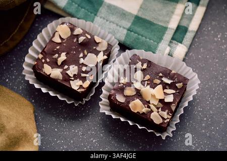 Deux riches brownies au chocolat nappés de tranches d'amandes croquantes Banque D'Images