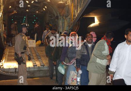 26 janvier 2005 ; Al Taqqadum, Irak ; Sgt. JAMES FORTE, un capitaine de chargement Hercules KC-130 de 36 ans de Ridgefield, Connecticut, regarde le dernier chargement de travailleurs de la Commission électorale indépendante d'Irak sortir de son avion cargo à Al Taqqadum, Irak janvier 26. Deux équipages et deux avions ont passé la majeure partie de la journée à transporter des centaines de travailleurs électoraux irakiens de Najaf, en Irak, pour les prochaines élections de janvier 30. Banque D'Images