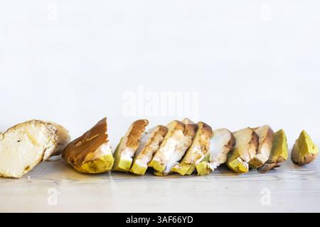 Rangée de champignons boletus coupés crus préparés pour la cuisson ou la conservation. Groupe de tranches de champignons isolées sur fond blanc. Vue de face. Gros plan. Copier Banque D'Images