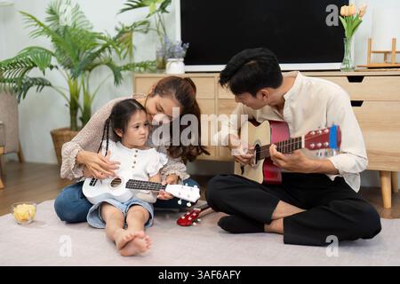 Moments musicaux en famille. Une mère et sa fille se liant tout en jouant des instruments. Banque D'Images