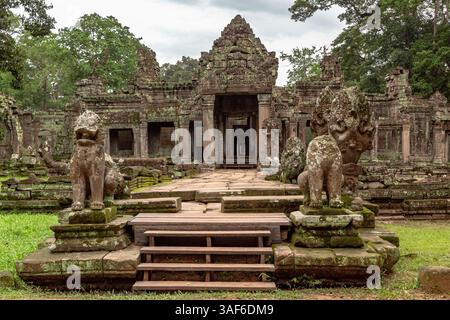 Design extérieur en pierre verte recouvert de mousse et statues d'entrée sacrées du temple Preah Khan dans la forêt verdoyante des ruines du site historique d'Angkor Wat Banque D'Images