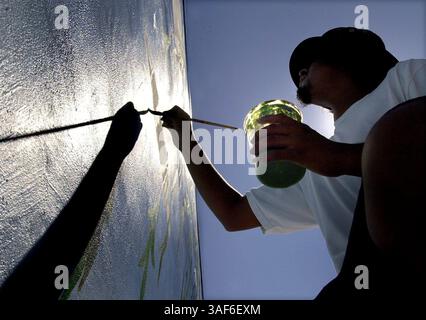 Avec le soleil projetant une longue ombre de son bras et pinceau, Pedro Valasquez (CQ) 16 ans de Sacramento applique de la peinture acrylique sur un 13 pieds. par 84 pieds Murale sur le côté du Franklin Center jeudi 26 juillet 2001. La murale est sur le côté de ce centre commercial de rue commerçante sur Franklin Blvd juste au nord de Fruitridge Blvd. La murale est réalisée par l'intermédiaire de la Sacramento Metropolitan Arts Commission, et le Sacramento County Regional occupation Program, par des étudiants du ROP qui sont payés, apprenant une compétence professionnelle, reçoivent une formation pour cette compétence en peignant la murale. Ils reçoivent également scho Banque D'Images