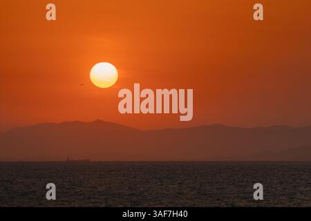 Avion prenant son envol au coucher du soleil au-dessus de la Chine Banque D'Images