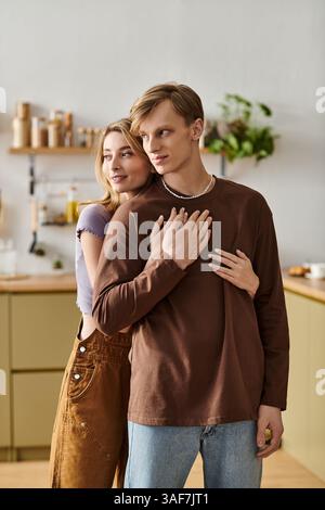 Un jeune couple partage un moment romantique dans leur cuisine élégante à la maison. Banque D'Images