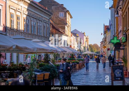 Brasov, Roumanie - 19 octobre 2024 : des guildes médiévales aux boutiques modernes : 800 ans d'évolution urbaine le long de la rue emblématique de Brasov Banque D'Images