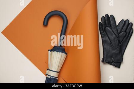 Crochet de parapluie, gants sur fond de papier plié. Mode minimaliste nature morte. Pose à plat. Vue de dessus Banque D'Images