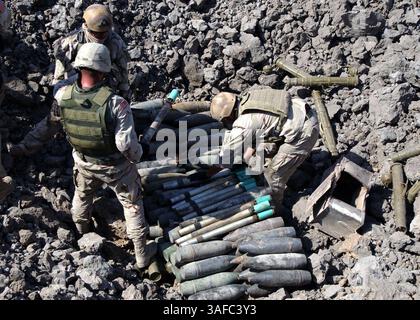 11 octobre 2003 ; Bagdad, IRAK ; les techniciens de la Marine chargés de la destruction des engins explosifs affectés à la Special Operations Task Force 56 basée à Bahreïn travaillent avec les techniciens de l'armée de terre pour préparer des engins non explosés pour démolition dans une zone de stockage sûre à proximité de Bagdad. Les équipes conjointes de lutte contre la destruction des munitions non explosées de l'armée et de la marine travaillent avec diligence pour détruire les quantités considérables d'UXO disséminées dans tout le pays afin de réduire et, à terme, d'éliminer les armes et munitions dont disposent les insurgés pour les utiliser contre les troupes de la coalition. (Image de crédit : ZUMA Press/ZUMAPRESS.com) Banque D'Images