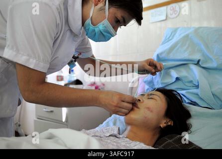 05 août 2008 - Kashi, Xinjiang, Chine - Zhou Wenxian, une policière blessée dans l'attaque terroriste, reçoit des soins médicaux à l'hôpital populaire préfectoral de Kashi dans la ville de Kashi, dans la région autonome ouïgur du Xinjiang, au nord-ouest de la Chine, le 5 août 2008. Seize policiers ont été tués et 16 autres blessés dans une attaque terroriste devant la porte de la division de la police frontalière de Kashi lundi, selon un responsable local. Les 16 blessés ont été soignés à l'hôpital populaire de la préfecture de Kashi. Quatre d'entre eux étaient dans l'unité de soins intensifs de l'hôpital, tandis que les 12 autres étaient hors de danger (crédit image : ZUMA Pres Banque D'Images