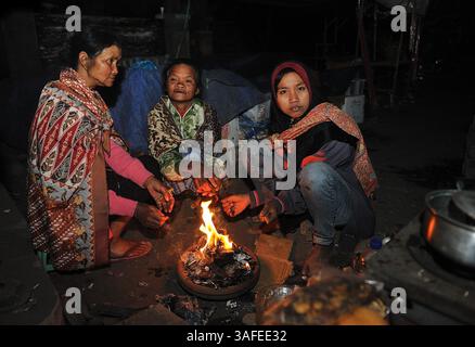 4 août 2012 - Probolinggo, Java oriental, Indonésie - la tribu Tengger assise près de la cheminée pour se réchauffer en attendant la fin de la cérémonie de Yadnya Kasada. La température de l'air autour du mont bromo était très froide. Yadnya Kasada cérémonie organisée par le Tenggerese hindou anually dans le temple Luhur Poten, zone sacrée au mont bromo mer de sable. Les Tenggerese donnèrent des offrandes à Dieu sous de nombreuses formes, sajenan, suguhan et tassement. Kasada est l'un des fameux agenda touristique de l'Indonésie qui pourrait attirer les touristes nationaux et étrangers venir à bromo. (Crédit image : © Robertus Pudyanto/ZUMAPRESS.com) Banque D'Images